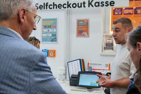 Regionalleiter Danny Erdmann erklärt die Selbstbedienungskasse im Tante Enso Markt Falkenau. Foto: Stadtverwaltung Flöha/ Erik Frank Hoffmann
